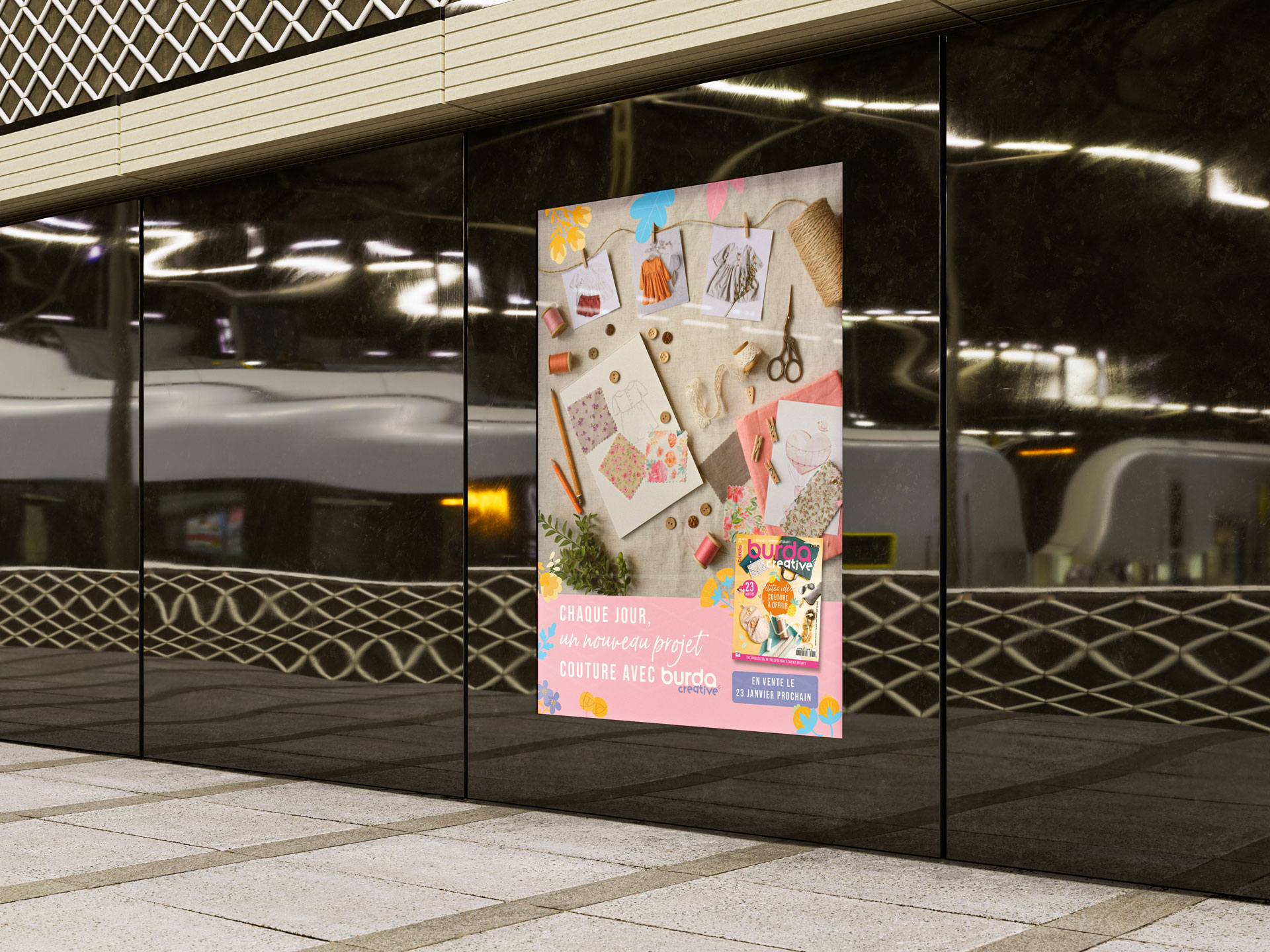 Affiche publicitaire de Burda Creative installée sur un mur en ville, illustrant la promotion d'un magazine de couture avec un logo attractif.