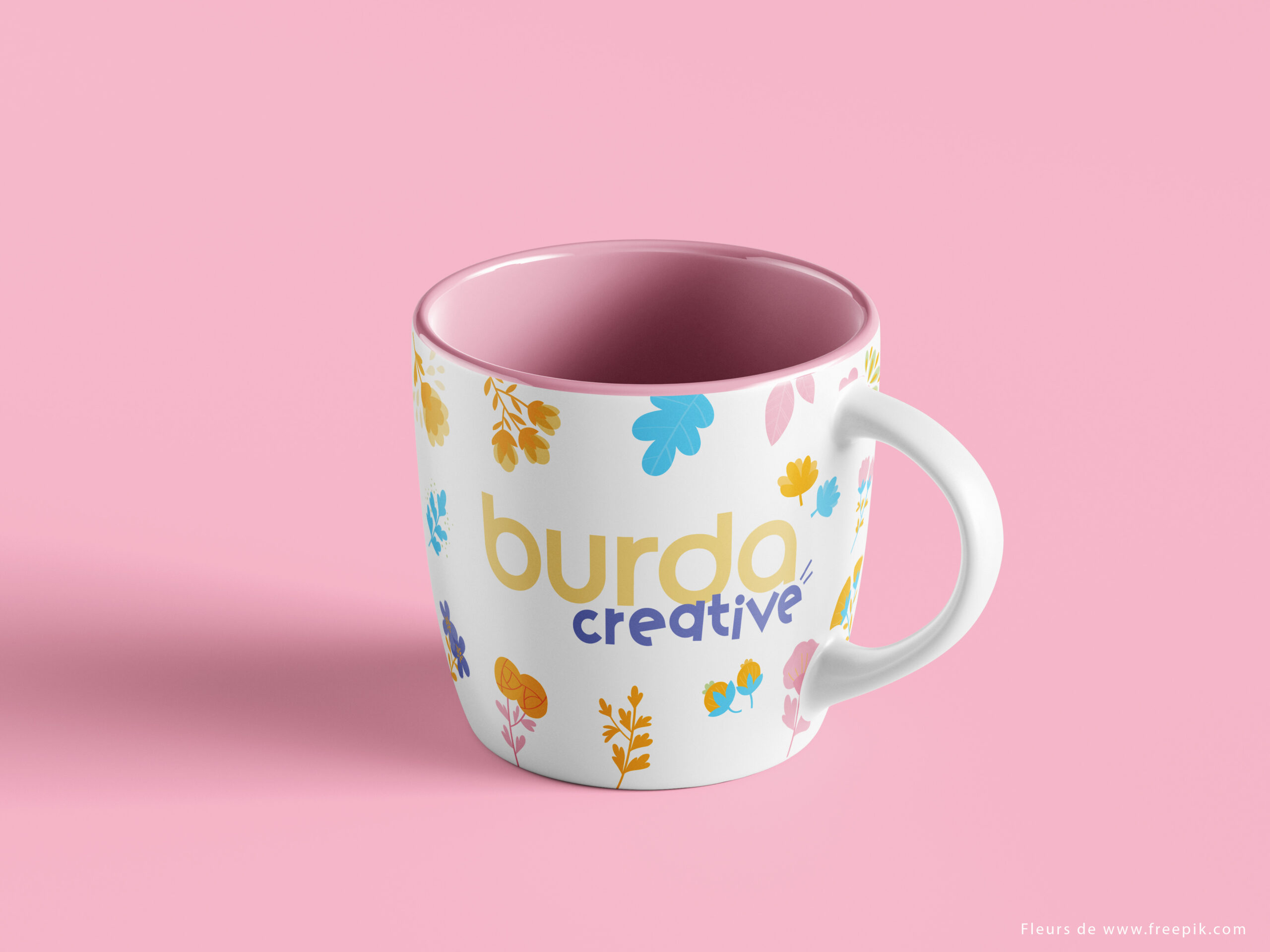 Mug illustré avec le logo Burda Creative et des motifs floraux, mettant en avant l'identité graphique d'un magazine de couture.