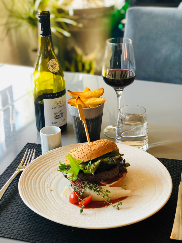 Plat hamburger gastronomique servi au restaurant L'Imaginaire, illustrant l'expérience culinaire haut de gamme.