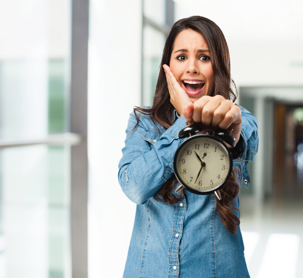 Femme en chemise en jean tenant une horloge avec un air surpris, illustrant la rapidité du service d'impression dans l'identité visuelle de l'imprimerie.