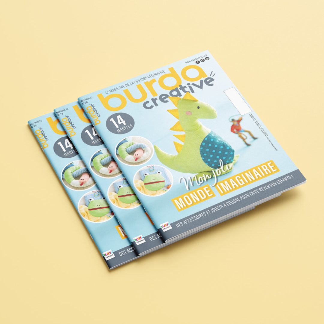 burda_creative_Free_Letter_Catalog_Mockup_02 Mockup de magazines Burda Creative empilés sur un fond jaune, mettant en avant le design du logo et l'identité visuelle d'un magazine de couture.